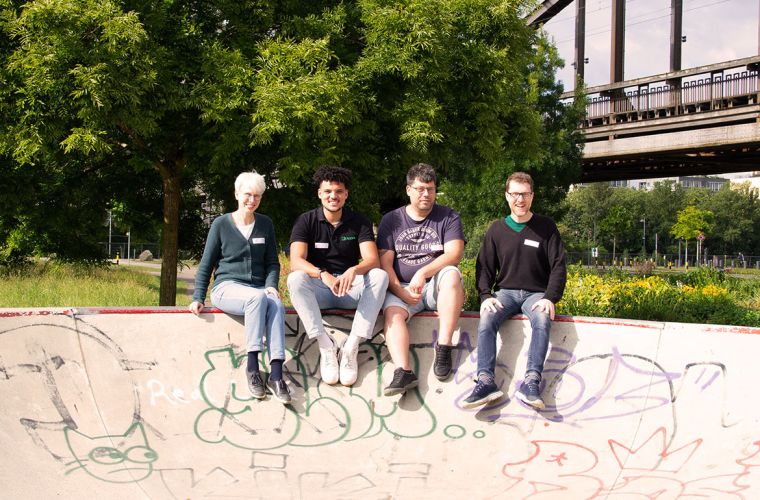 Gruppenfoto der Green IT Community mit einer Frau und drei Männern, die auf der Kante einer Halfpipe sitzen.