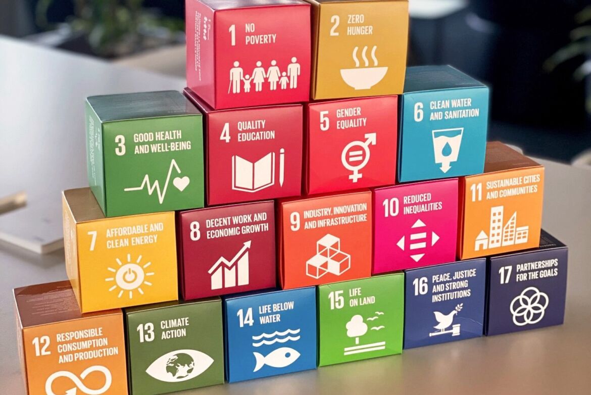 17 Würfel der SDGs in Papierform übereinander gestapelt