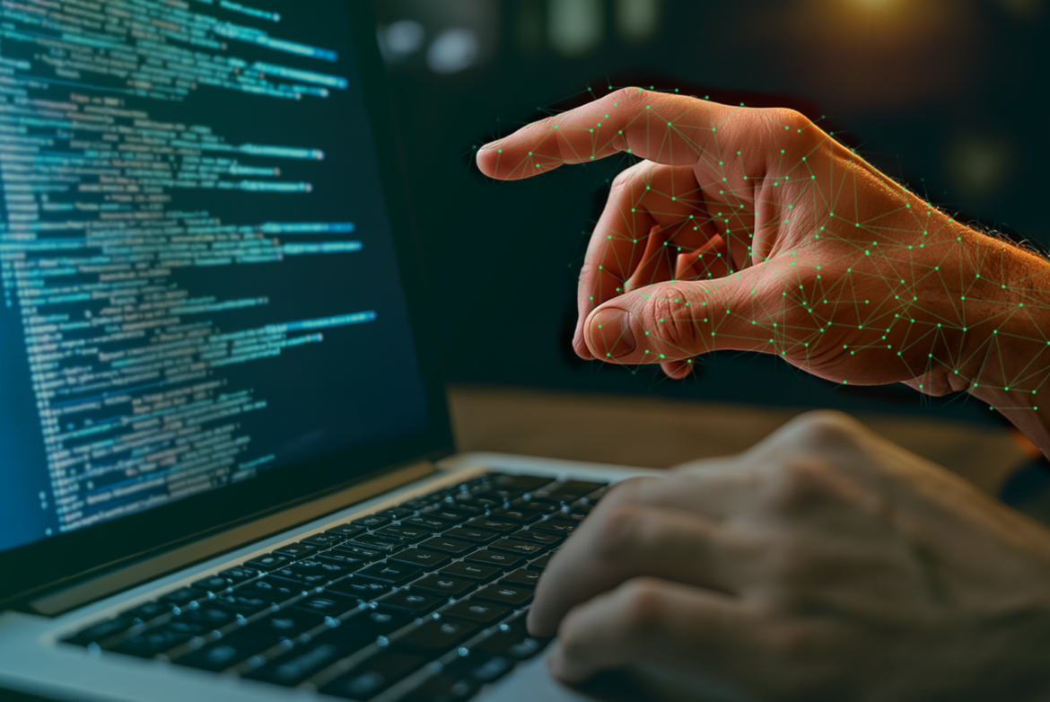 Zwei hände, die die Tastatur eines Laptops bedienen und Code verfassen. Eine Hand zeigt auf den Bildschirm.