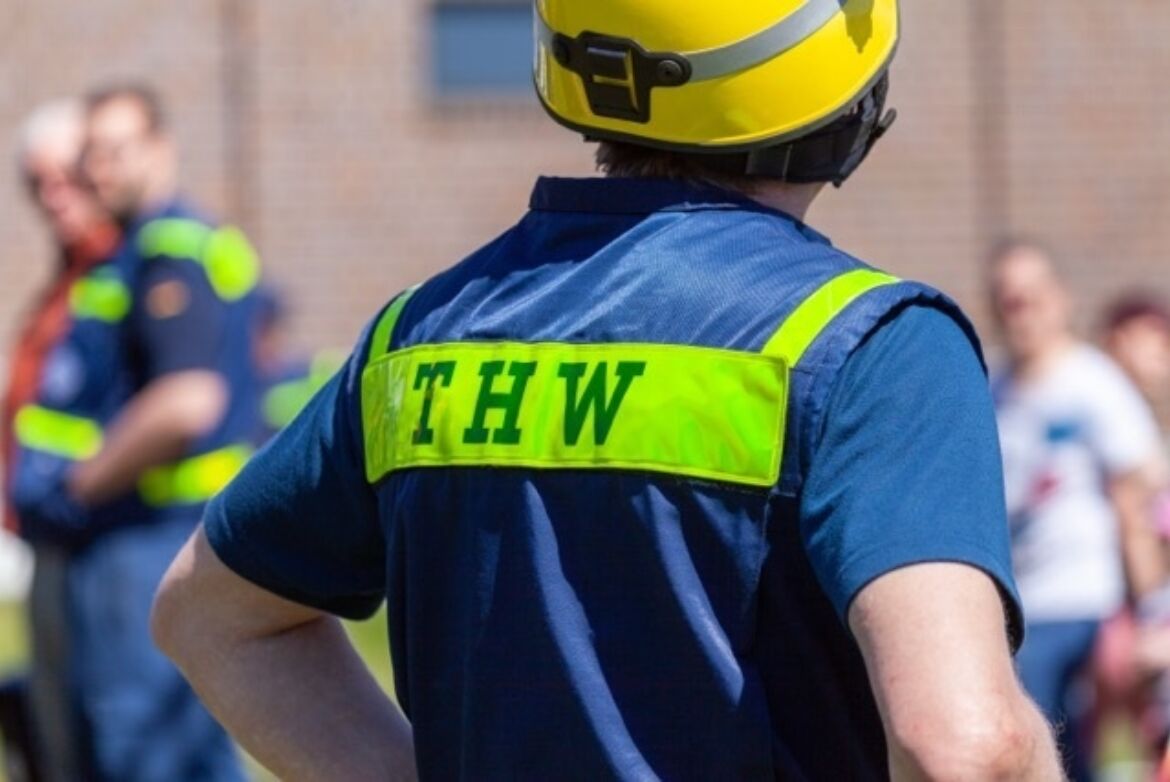 Mitarbeiter:in vom THW in Uniform von der Rückseite In Nahaufnahme zu sehen.