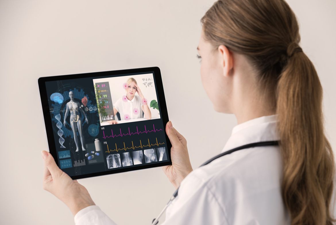 Eine Frau in weißem Kittel hält en Tablet mit sichtbaren Gesundheitsdaten.