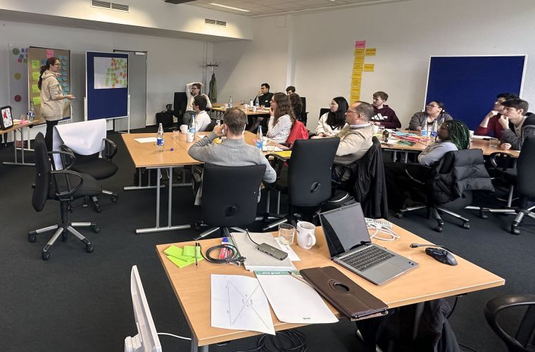 Ein Raum mit einer Gruppe von Menschen, die sich ein einem Workshop befinden