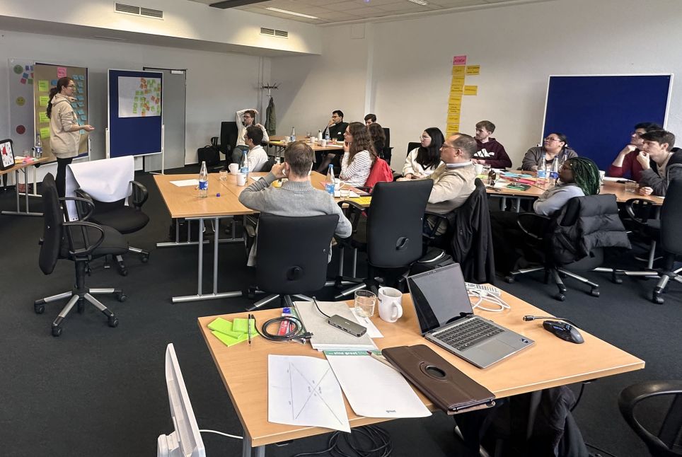 Ein Raum mit einer Gruppe von Menschen, die sich ein einem Workshop befinden