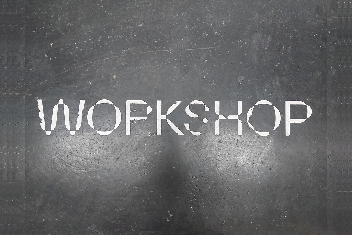 Das Wort "Workshop" in weißer Schrift auf einem grauen Hintergrund, der an Schiefer erinnert.